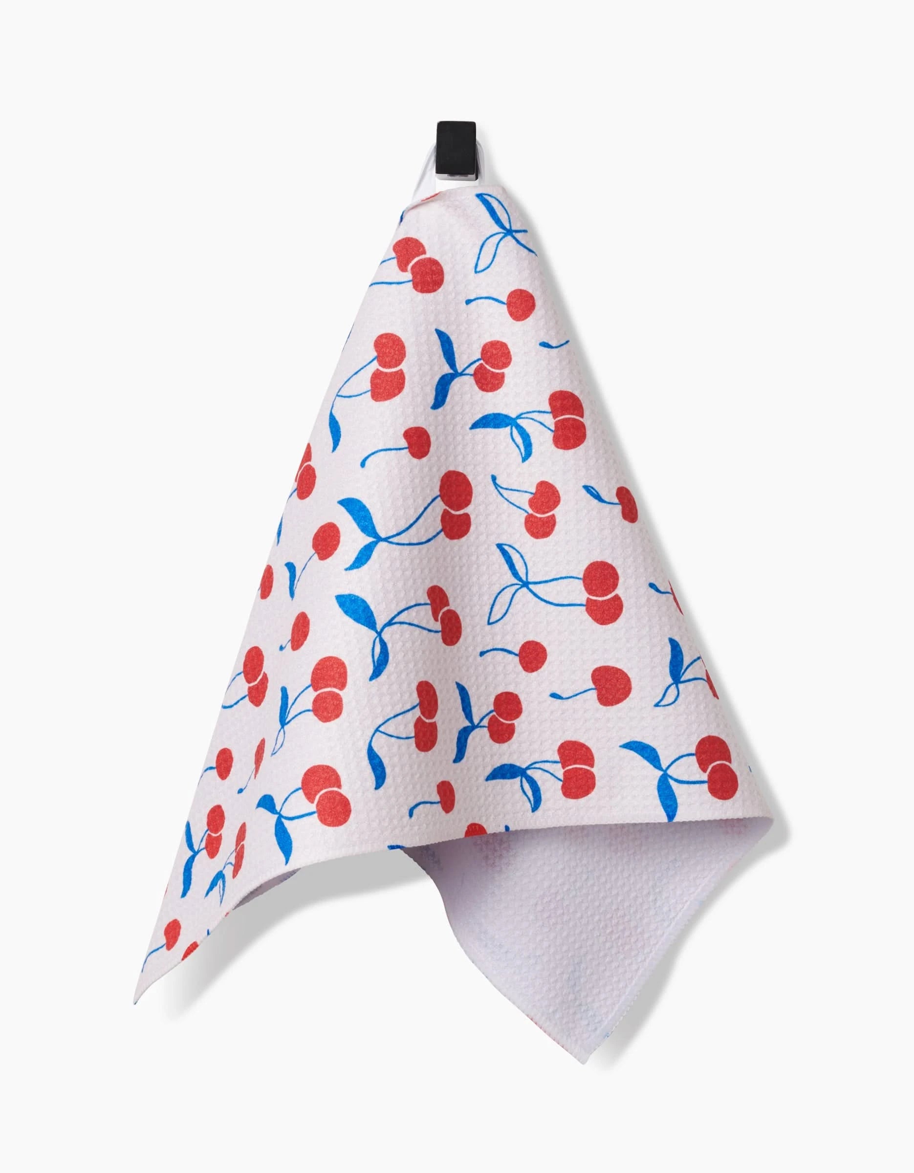The Kayla Ann Very Cherry Bar Towel, made from recycled materials and adorned with red cherries and blue stems, hangs from a black loop against a plain white background.