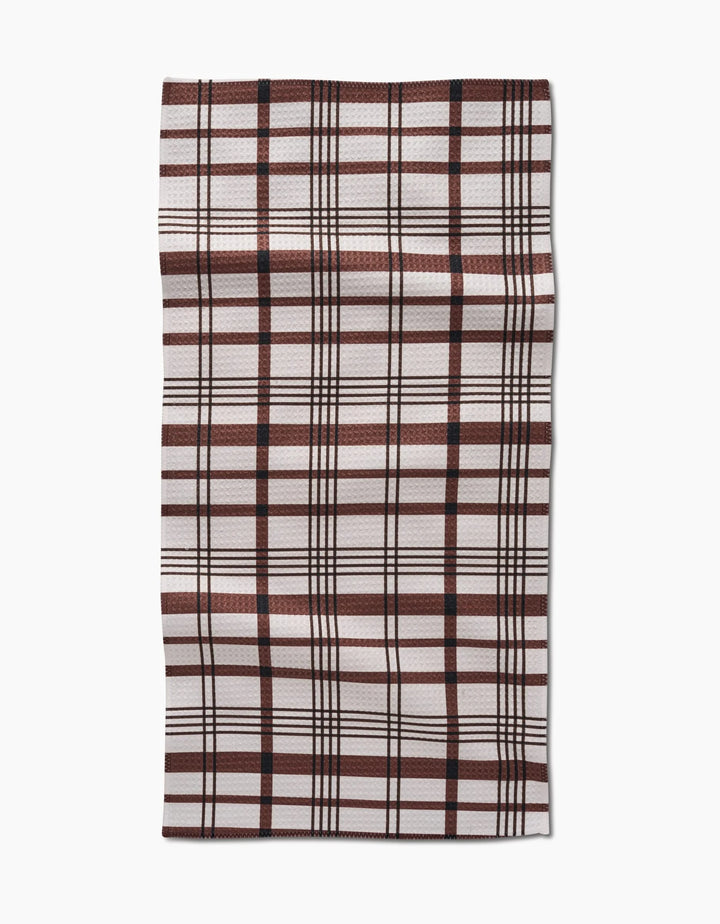 The Hufton Studio Vintage Plaid Natural Bar Towel features a rectangular shape and Geoweave fabric with a brown, black, and off-white plaid pattern of intersecting lines. It’s shown laid flat against a white background.