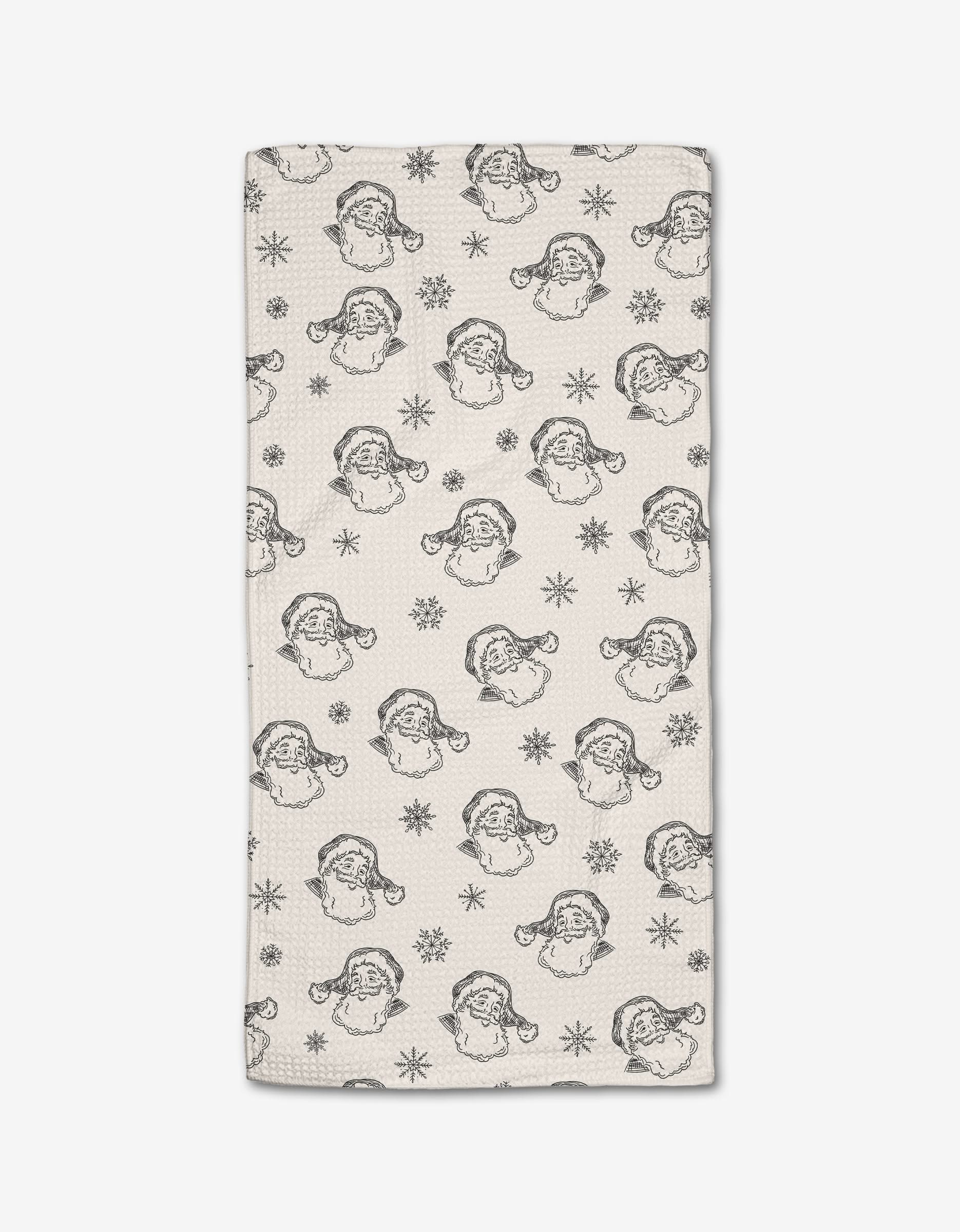 The Vintage Santa bar towel by Aubrey Fairchild is made from recycled materials and features a repeating pattern of vintage-style Santa faces and snowflakes in black outlines on geoweave fabric.
