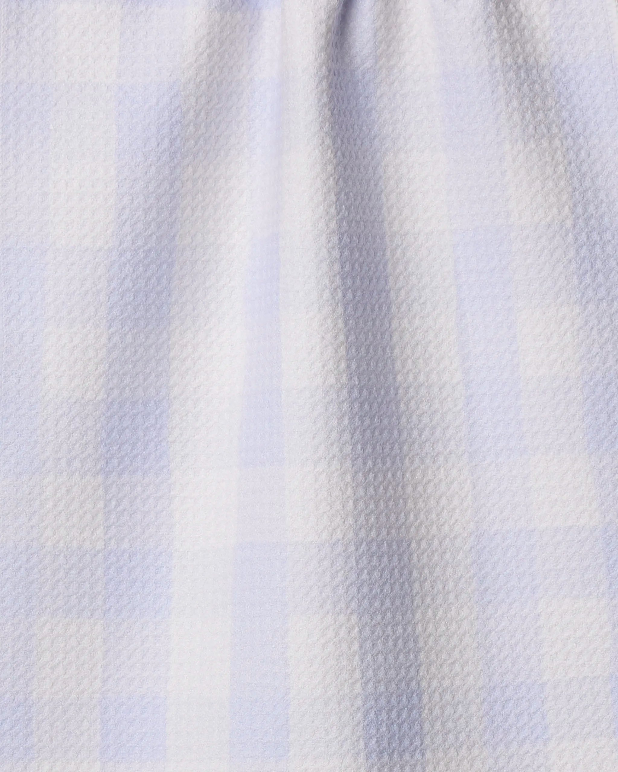 The Geometry Violetta towel features a light blue and white checkered pattern with ultra-absorbent fabric, subtle texture, and soft gathering at the top for gentle vertical folds.