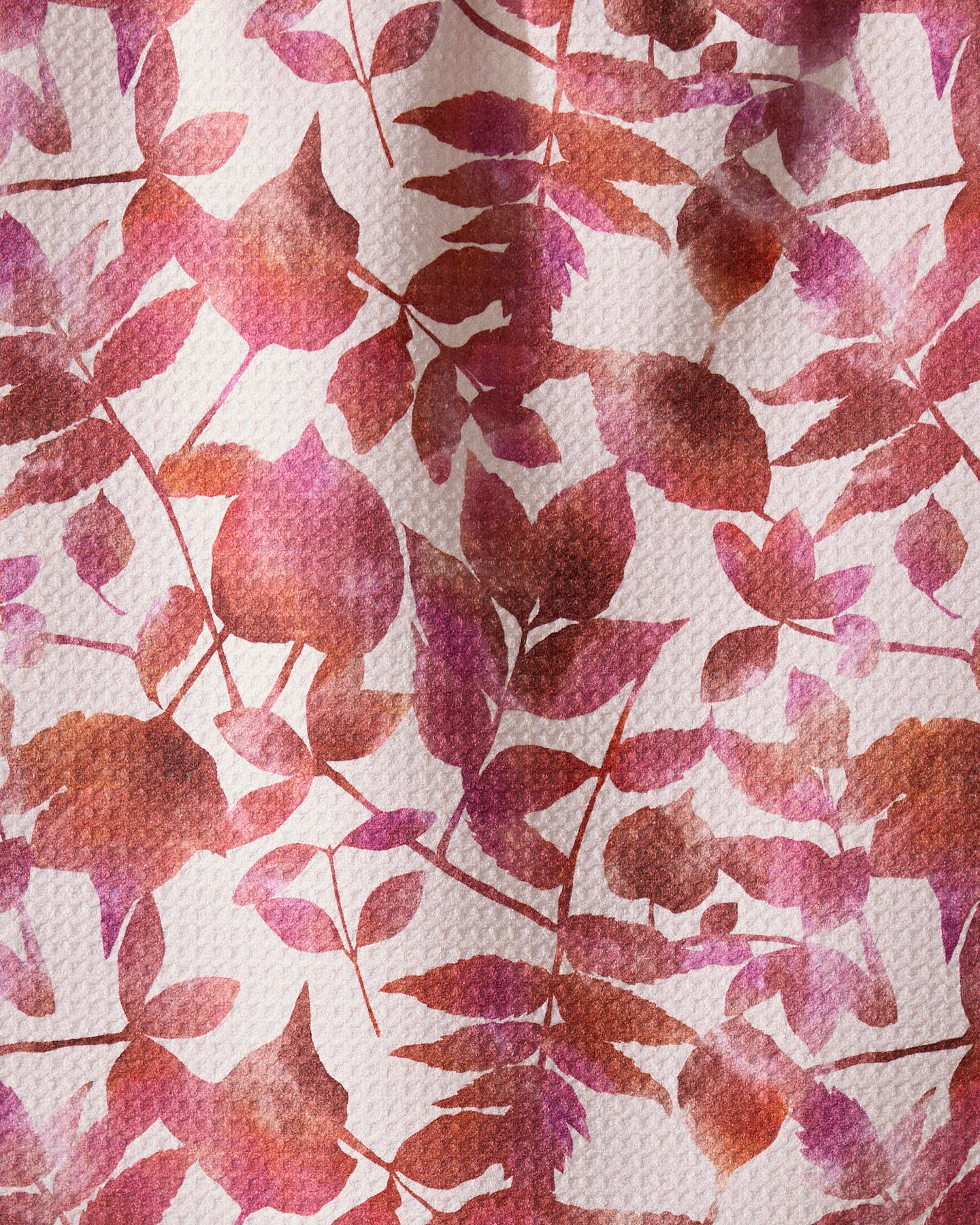 Geometrys Watercolor Dreaming towel features a soft, artistic botanical design with overlapping red, pink, and orange leaves on textured white—perfect for an ultra-absorbent addition to your kitchen.