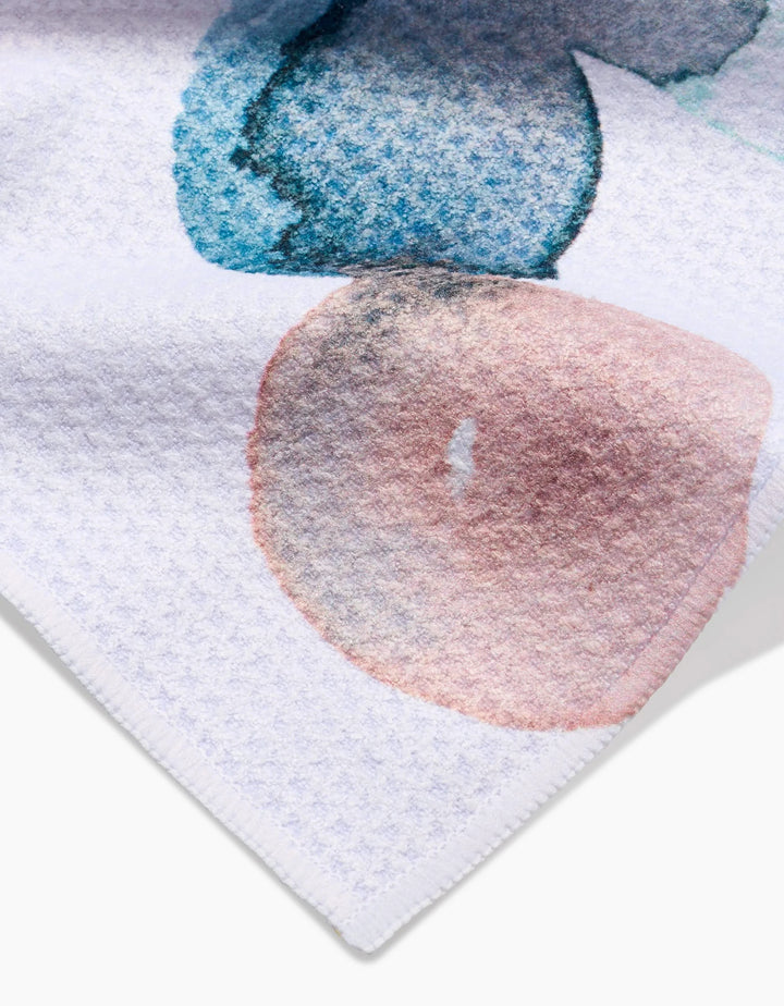 Close-up of the Taryn Brennan Watercolor Rocks bar towel in white Geoweave fabric, featuring abstract blue and peach watercolor-style shapes with stitched edges and soft texture detail.