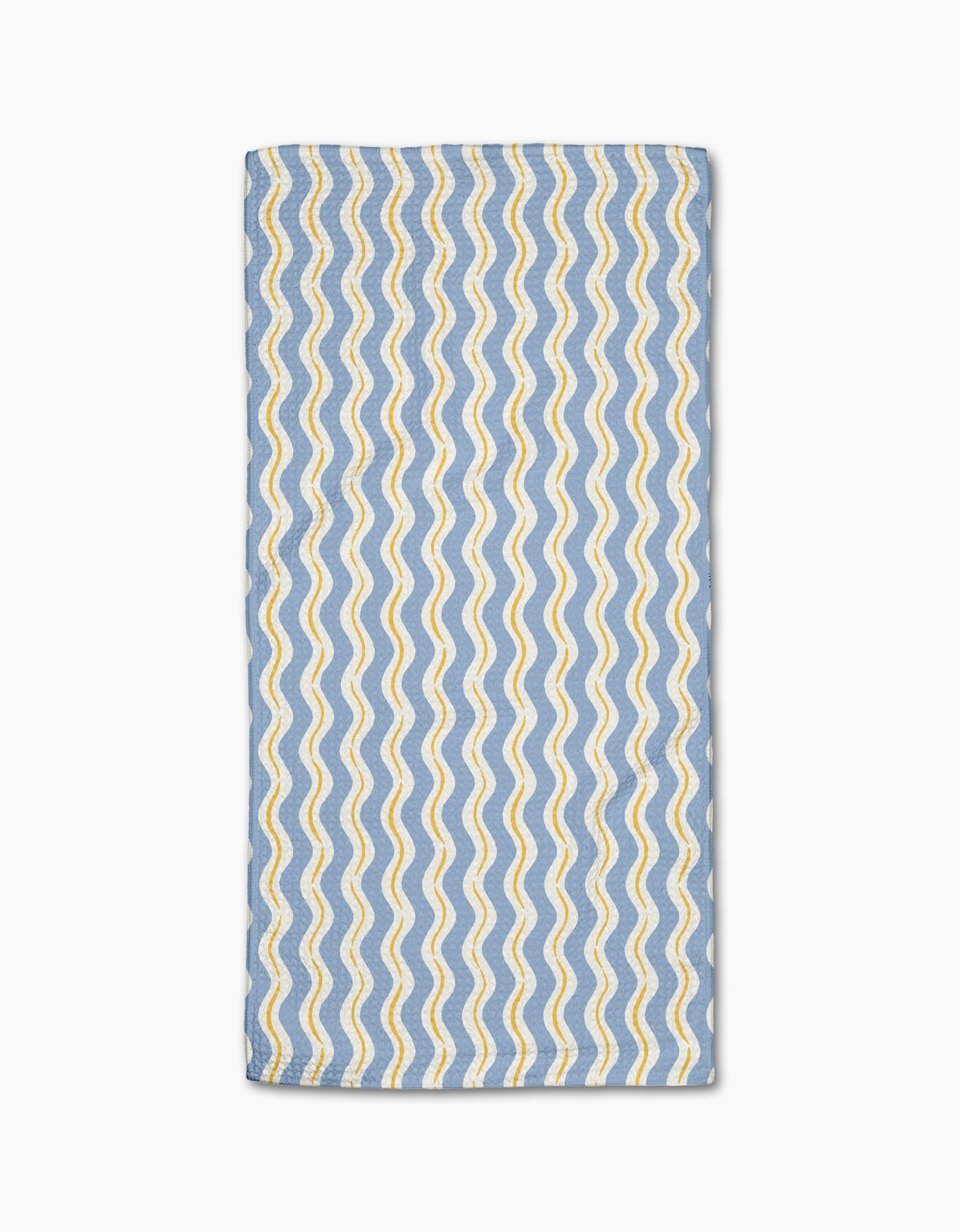 The Wave Ripple Stripes bar towel by Hufton Studio features a rectangular blue Geoweave fabric with wavy yellow and white parallel lines in a repeating pattern, neatly folded and displayed on a white background.
