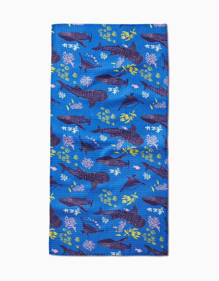 The Elisabeth Wing Whale Shark Bar Towel features a vibrant underwater pattern with sharks, coral, and fish in blue, yellow, pink, and white. Made from Geoweave fabric for enhanced absorbency and softness.