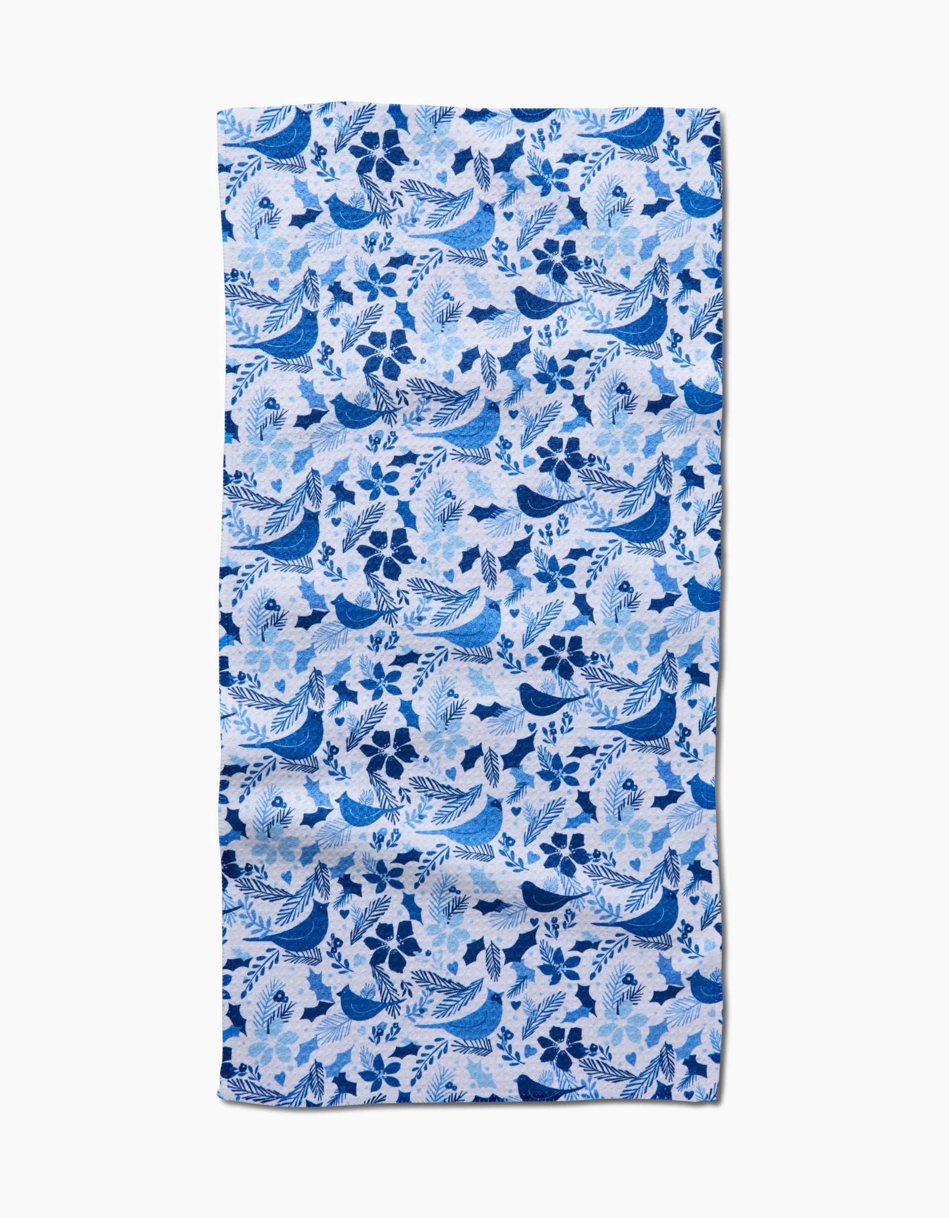 A rectangular blue and white ultra-absorbent towel by Kris Ruff, called Winter Blue Birds, featuring a repeating pattern of birds, waves, and flowers in blue tones. The cloth has slight wrinkles and is displayed on a white background.