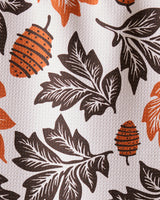 The Geometry Woodland Waltz bar towel features black leaves and orange pine cones on a white background with a textured, ultra-absorbent surface made from recycled materials.