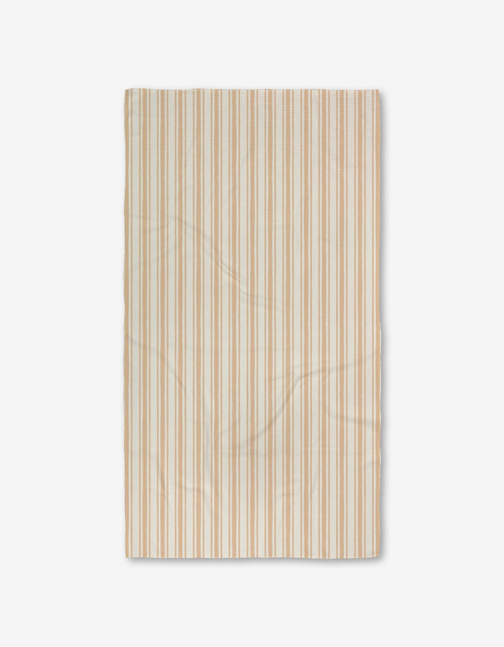 The Boho Stripe Luxe Bath Towel by Hufton Studio is a rectangular beige towel with thin tan and light brown stripes, featuring ultra-absorbent Geoweave fabric. It is shown flat on a white background with subtle texture and slight creases.