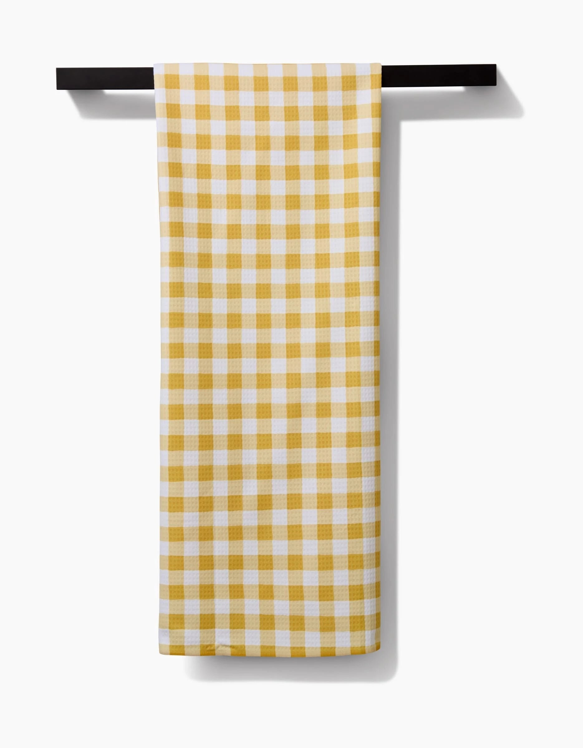 The Danelys Sidron Golden Plaid dish towel, made with Geoweave technology, is shown neatly folded over a black towel bar against a plain white background.