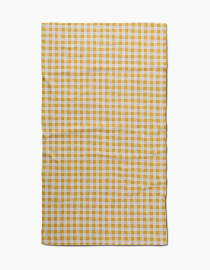 The Golden Plaid by Danelys Sidron is a rectangular cloth with a yellow and white checkered gingham pattern, crafted from recycled materials. Neatly laid out on a white background, it features slight wrinkles and uneven edges.