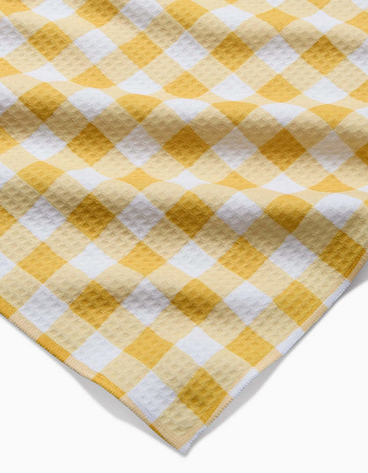 A close-up of Danelys Sidron’s Golden Plaid shows its yellow and white checkered Geoweave fabric with a waffle texture, displayed at an angle with detailed edge stitching.