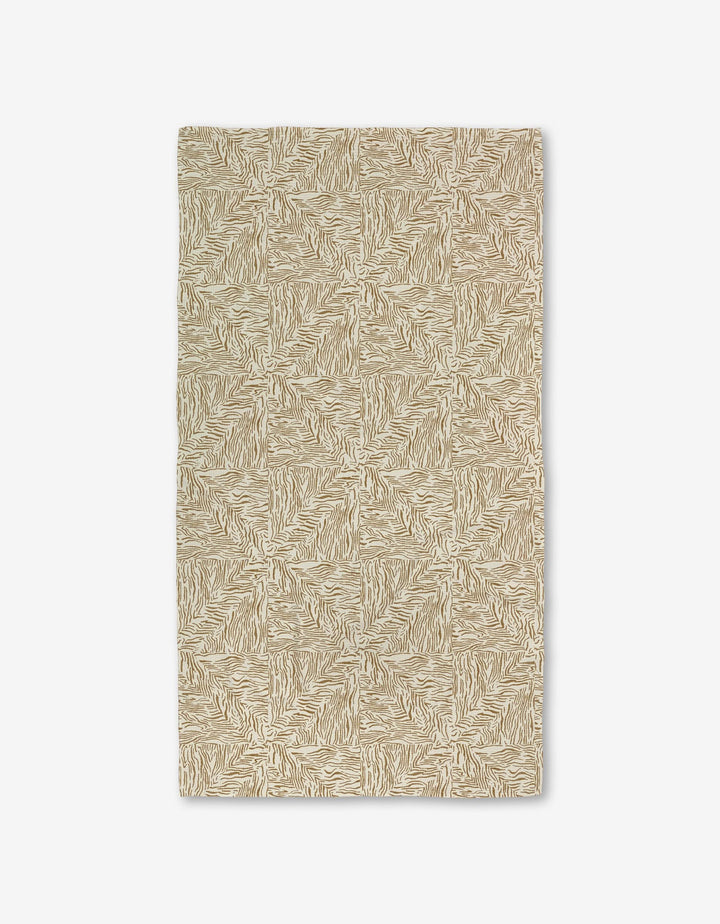 The Studio Jeannot Inlay rug is rectangular and beige with a repeating abstract geometric pattern. Made with Geoweave technology for added durability, it has a textured look and is shown flat on a white background.