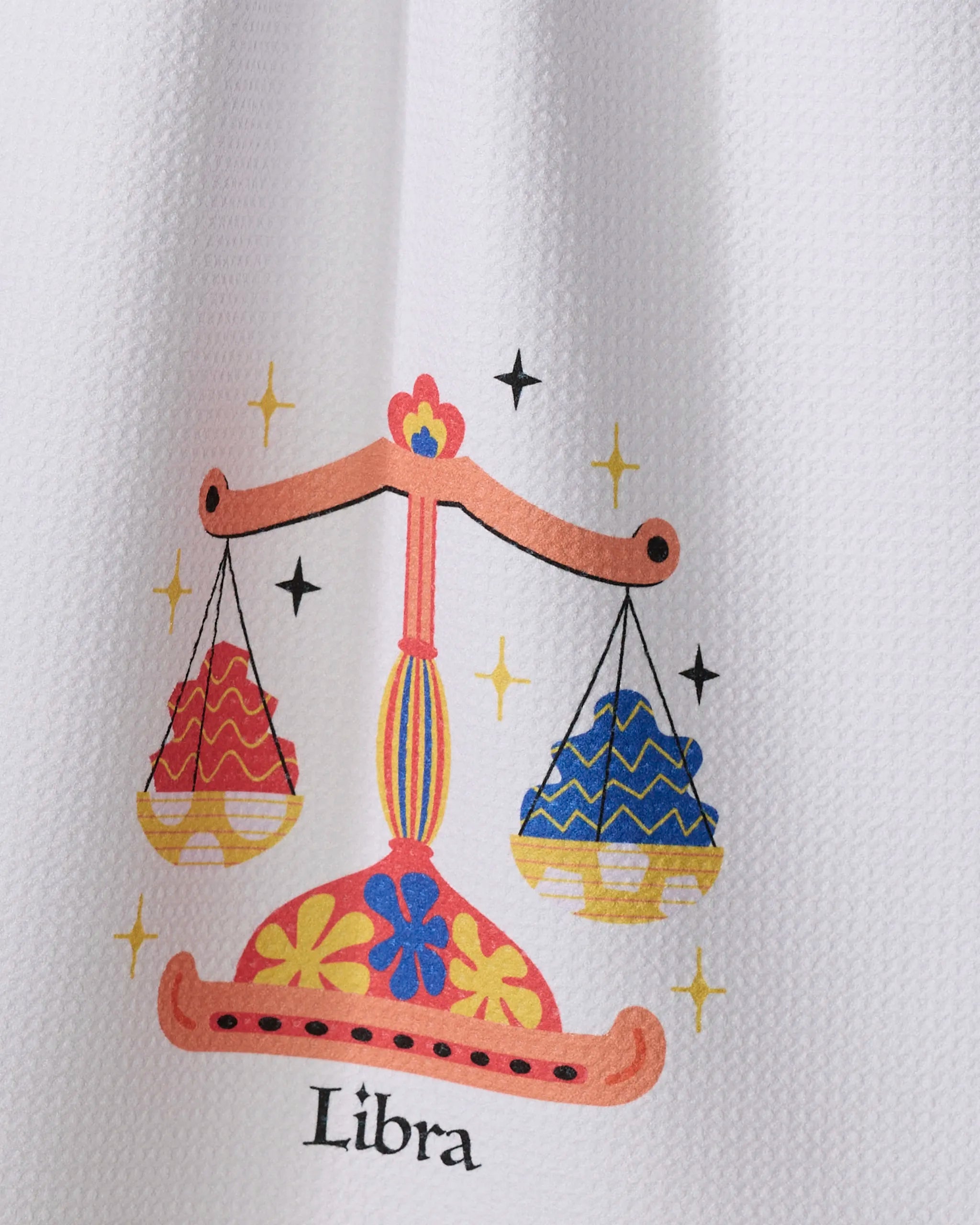 Charming Libra by Heather Zhou features a decorative orange scale with patterned, colorful bowls on a white textured background—perfect for adding celestial charm to a recycled kitchen towel. Stars and the word "Libra" appear below.