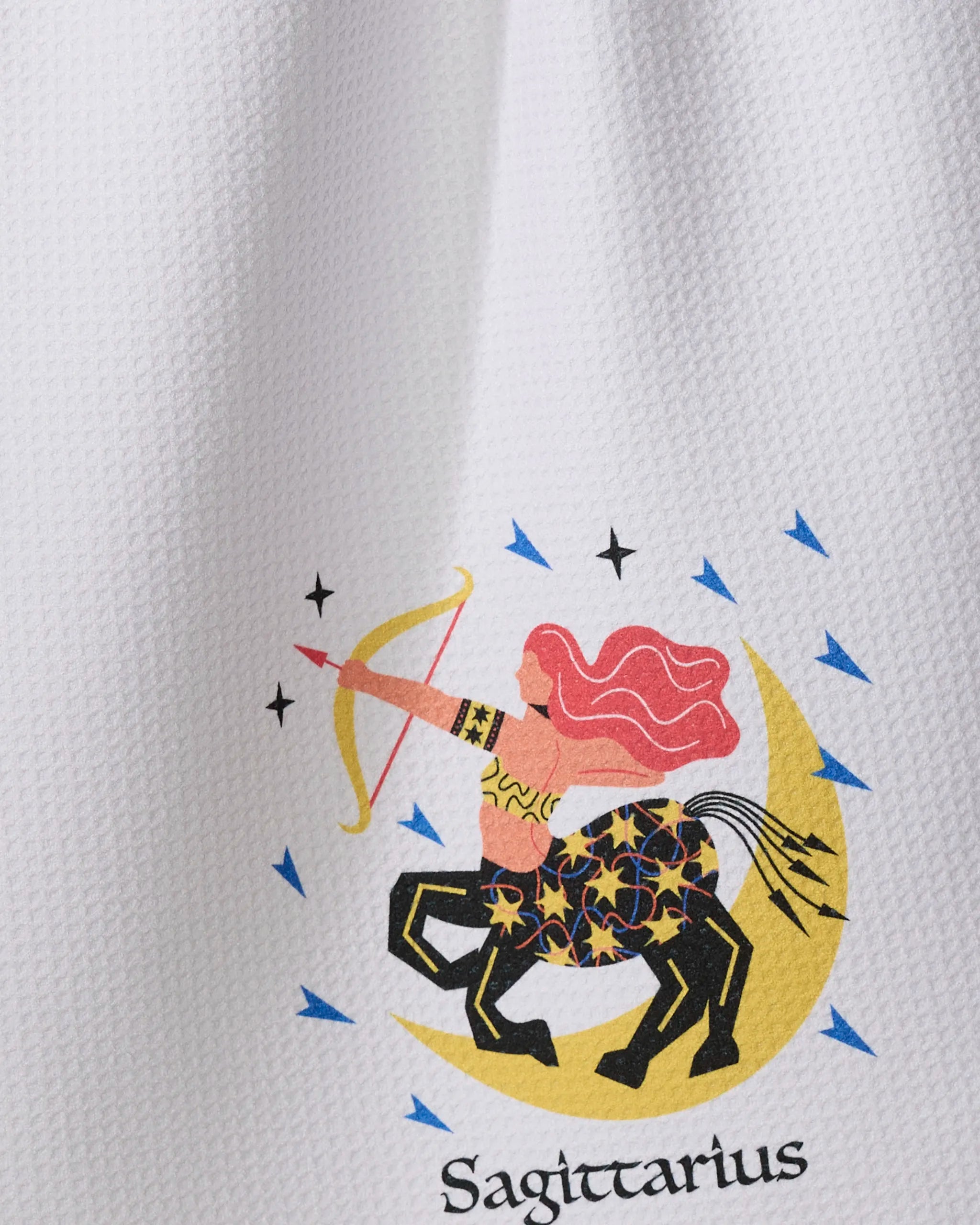 Wild Sagittarius by Heather Zhou features a centaur archer with flowing red hair, aiming a bow on a yellow crescent moon—surrounded by blue lines and black stars, on an ultra-absorbent recycled tea towel.