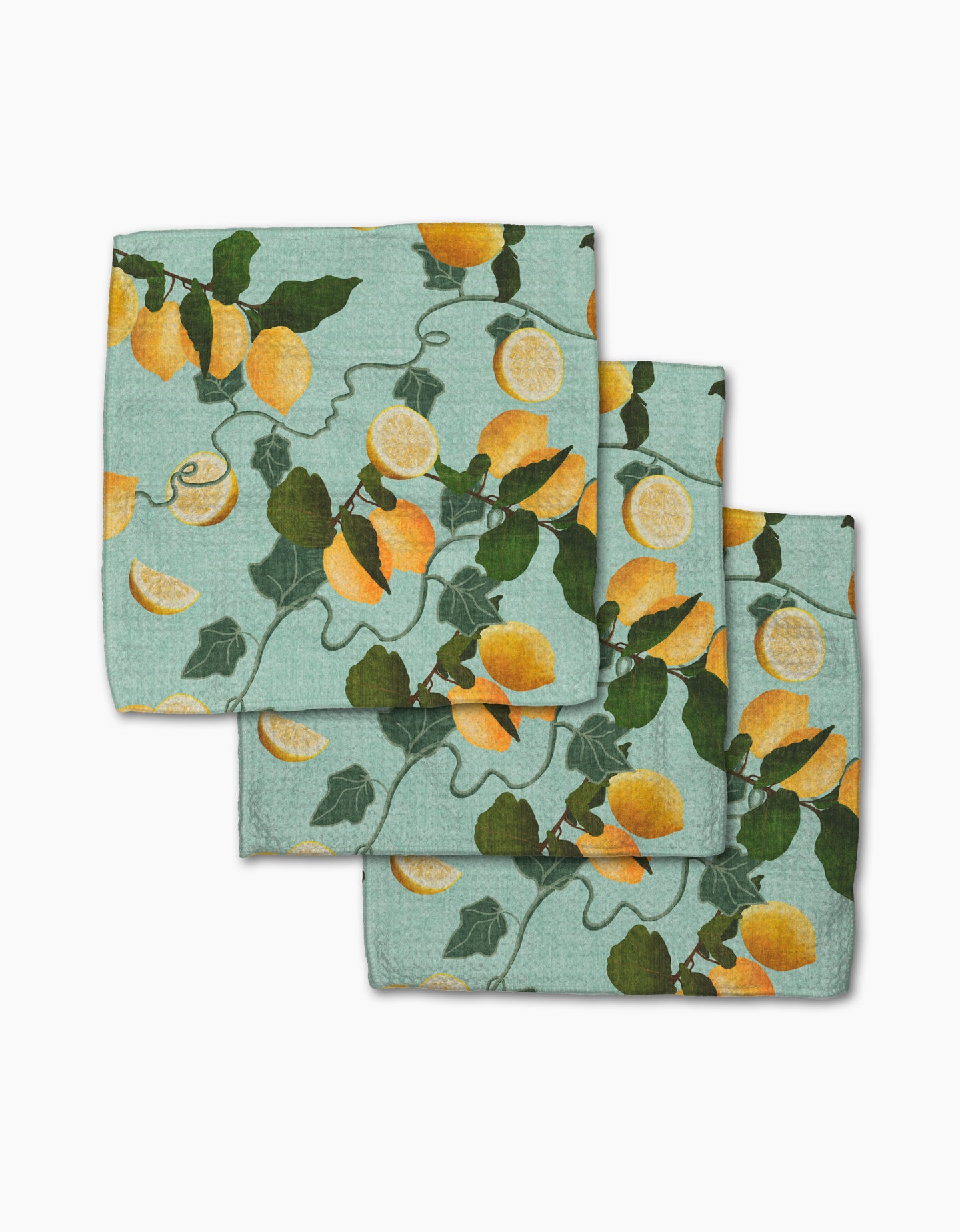 Three folded Pascale Dilger Amalfi Lemon dishcloths, light blue with yellow lemons, green leaves, and vines, are arranged on a white background—an eco-friendly set made from recycled materials.