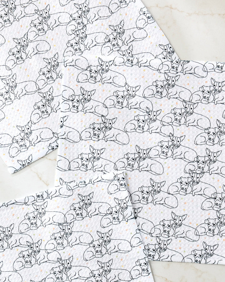 The Berry and Louie set by Sweet Simple Vegan includes four eco-friendly kitchen towels with black line fox patterns and orange dots, displayed on a light marble surface.