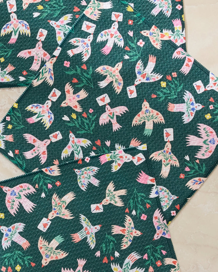 Birdsong Post by Ceyda Alasar features colorful birds with envelopes amid flowers and leaves on a dark green background—ideal for absorbent dishcloths or a unique recycled dishcloth set.