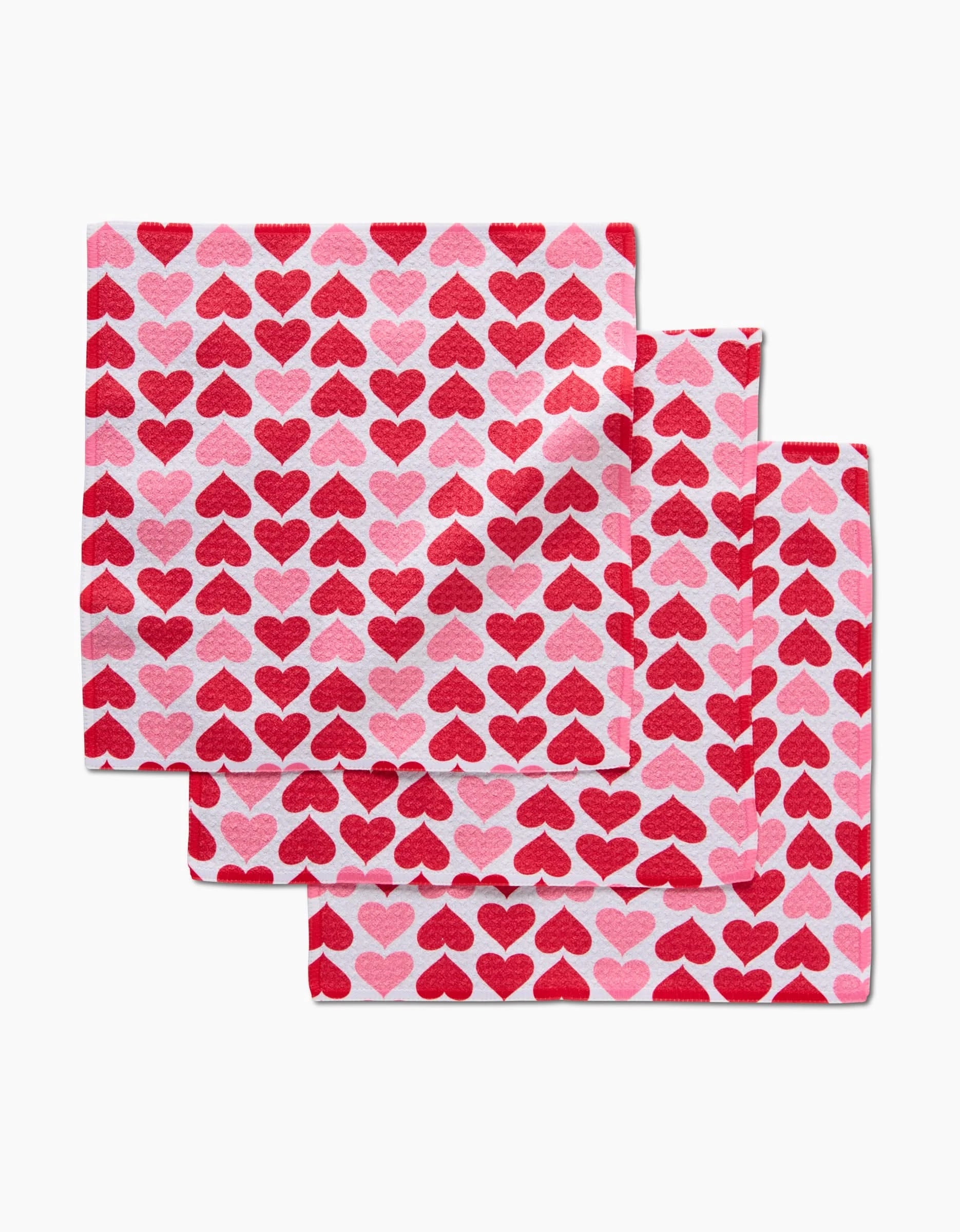 The Danelys Sidron Blushing Hearts set features three absorbent dish towels with red and pink heart patterns on white—practical and adorable for any kitchen.