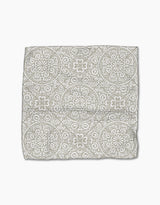 The Boho Medallion cloth napkin by Kris Ruff is crafted from Geoweave fabric and showcases a gray and white medallion pattern on a white background, displayed flat against a white surface.