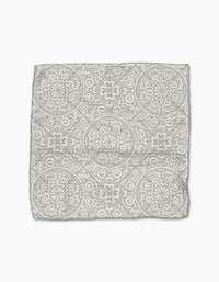 The Boho Medallion cloth napkin by Kris Ruff is crafted from Geoweave fabric and showcases a gray and white medallion pattern on a white background, displayed flat against a white surface.