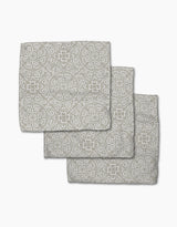 Three Boho Medallion cloth napkins by Kris Ruff, made from Geoweave fabric and featuring a gray and white floral and geometric medallion pattern, are arranged in an overlapping stack on a white background.