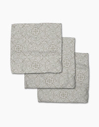 Three Boho Medallion cloth napkins by Kris Ruff, made from Geoweave fabric and featuring a gray and white floral and geometric medallion pattern, are arranged in an overlapping stack on a white background.