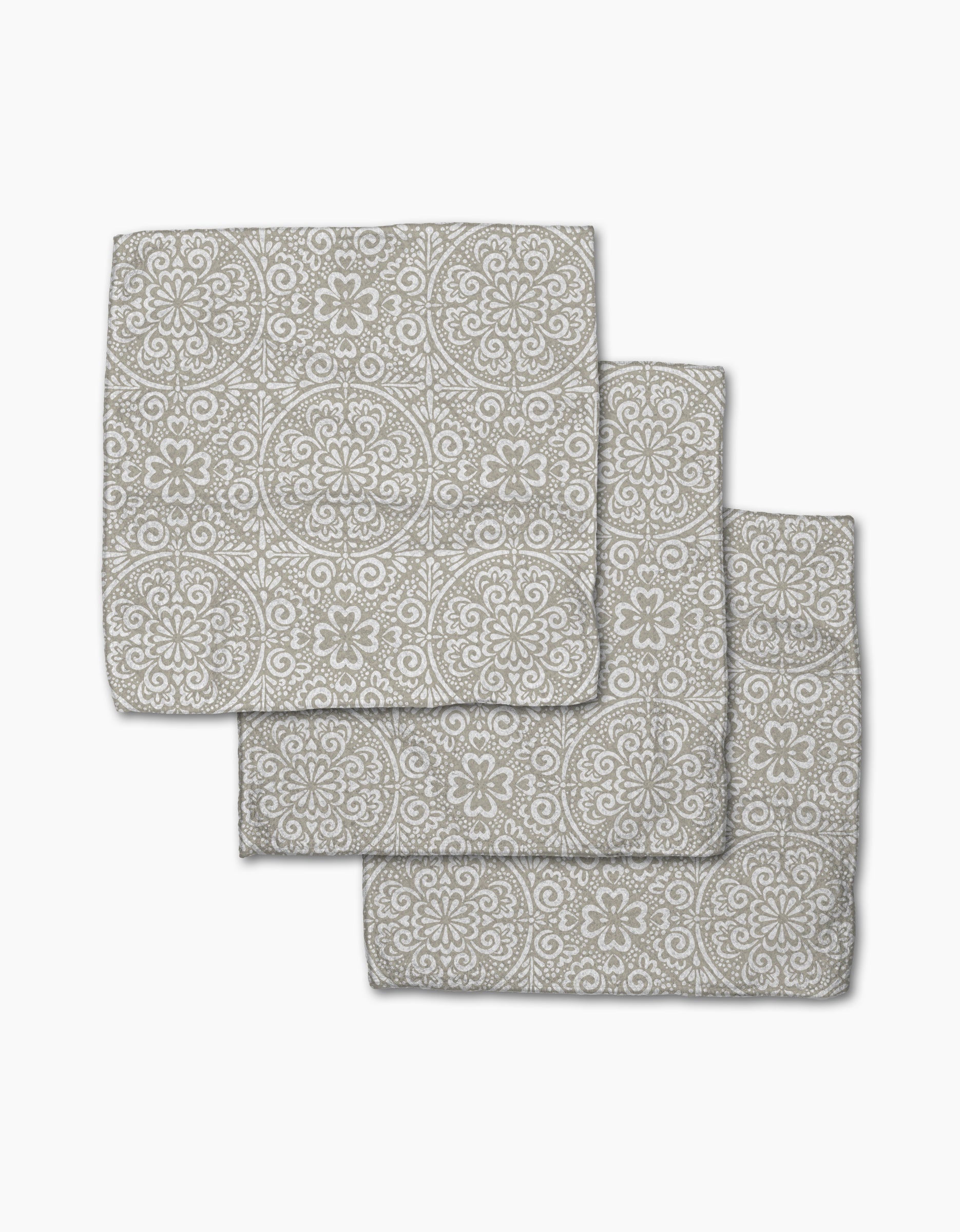 Three Boho Medallion cloth napkins by Kris Ruff, made from Geoweave fabric and featuring a gray and white floral and geometric medallion pattern, are arranged in an overlapping stack on a white background.