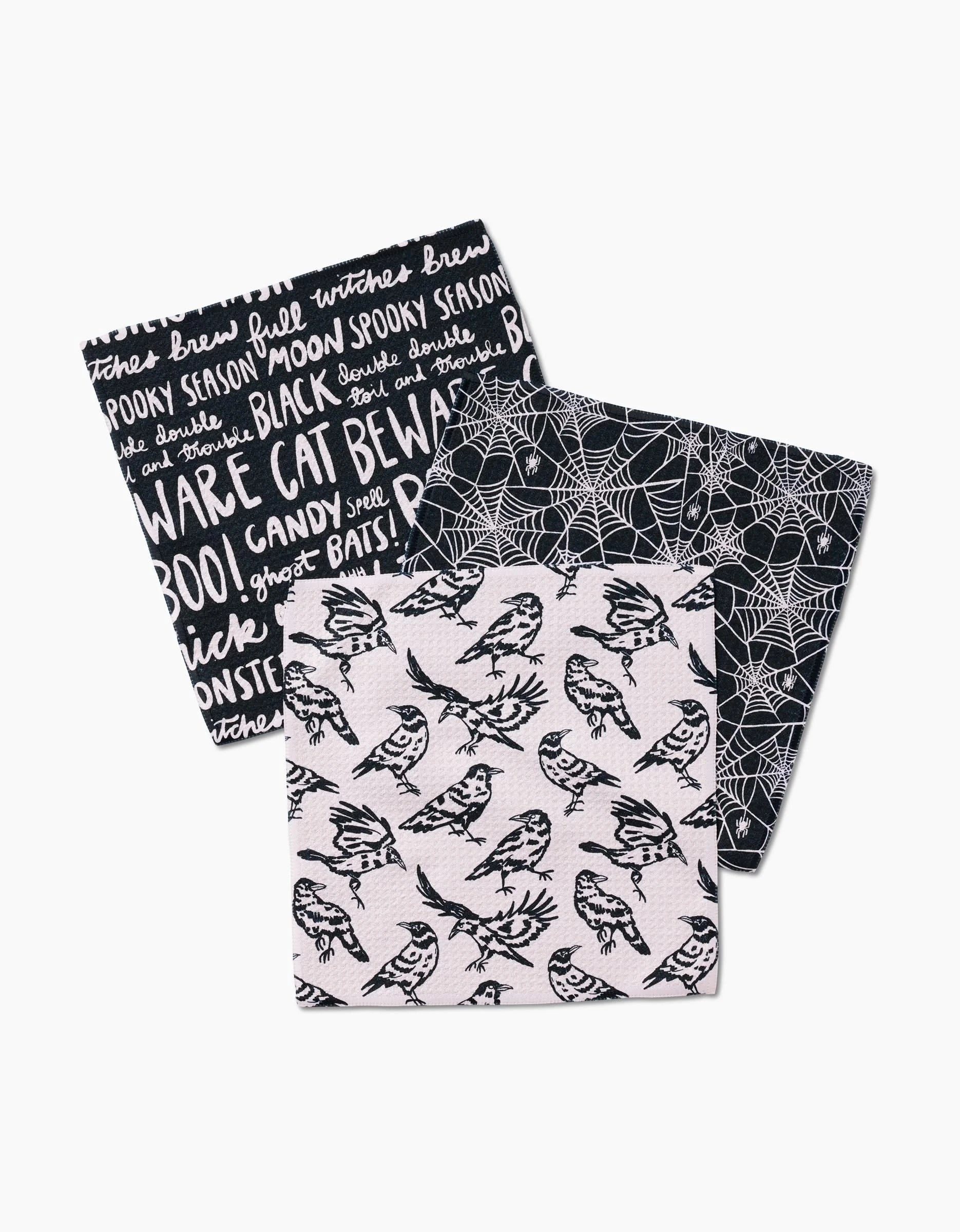 The Kayla Ann Booos set includes three Geoweave dishcloths with Halloween designs: spooky words, white spiderwebs on black, and black birds on branches against a light background.