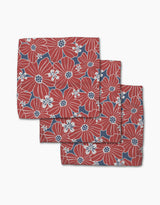 The Ashley Celena Botanical Blush set features three folded cloth napkins with bold red and white floral patterns on a dark blue background, neatly stacked for display against a crisp white backdrop.