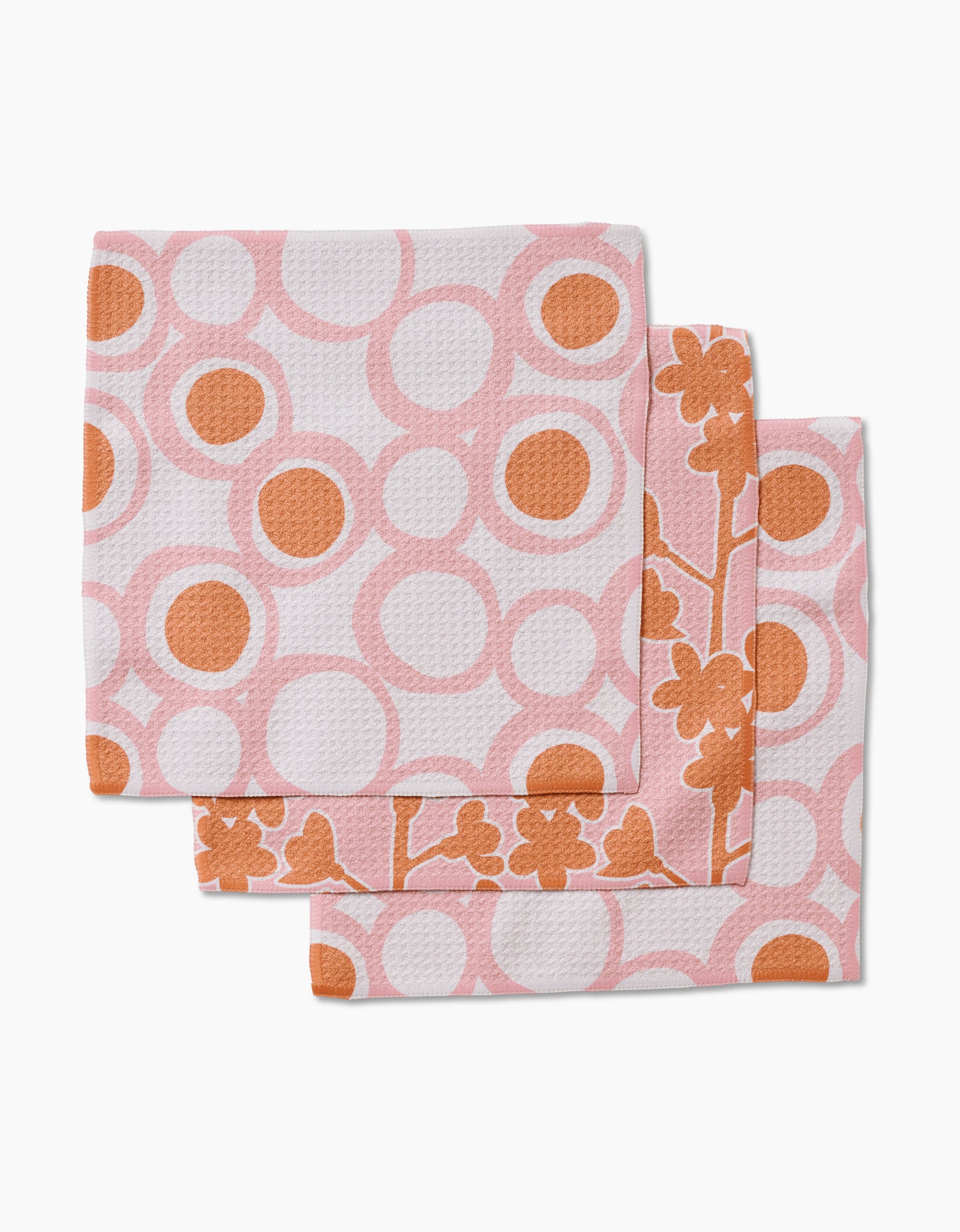 Three folded Bouncing Balls dishcloths by Lizzie Clark, each with a pink and orange circle and flower pattern, arranged overlapping on a white background. Made from recycled materials for eco-friendly appeal.