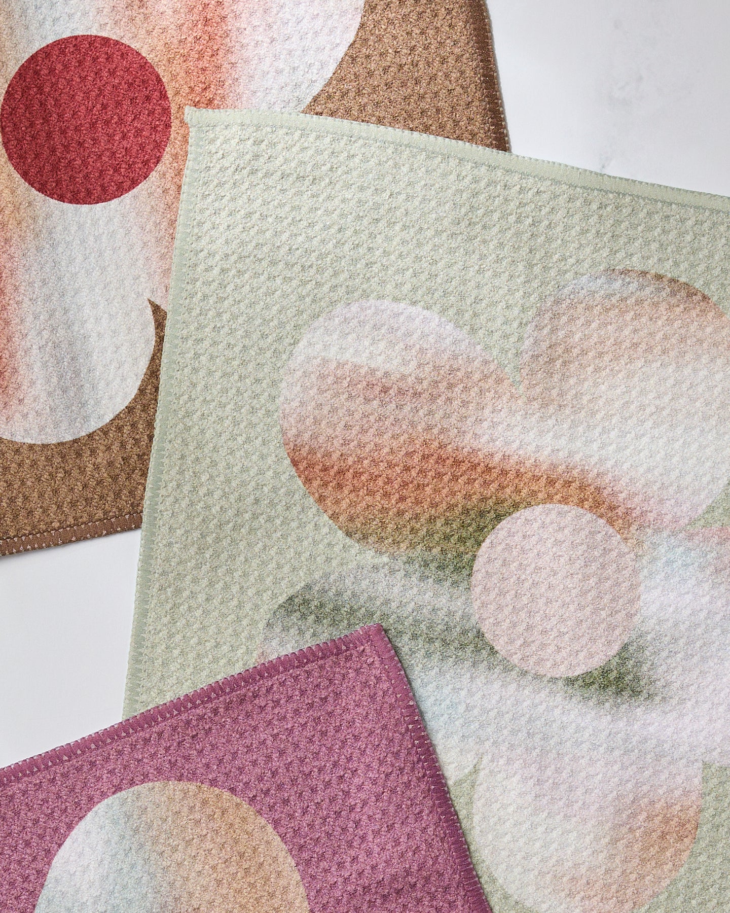 The Geometry Brushed Bouquet Dishcloth Set includes three super-absorbent, textured cloths featuring large floral patterns in soft hues. Made from recycled materials, they combine function and style for the modern kitchen.