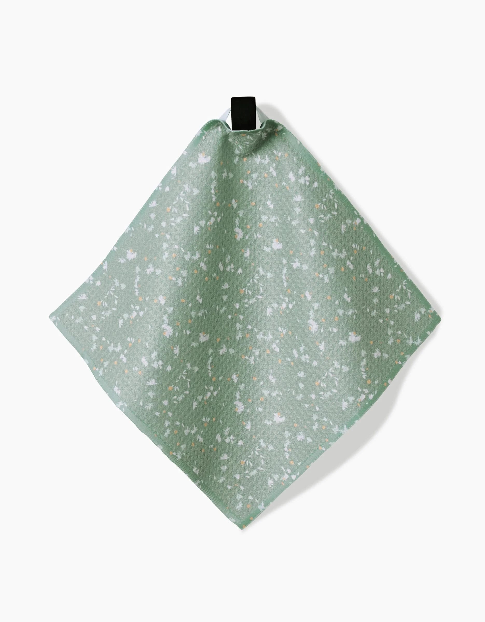 The Bunny Tea Time dishcloth by Second Nature Studio, crafted from super-absorbent Geoweave fabric with a green and white floral pattern, hangs from a black loop against a white background.