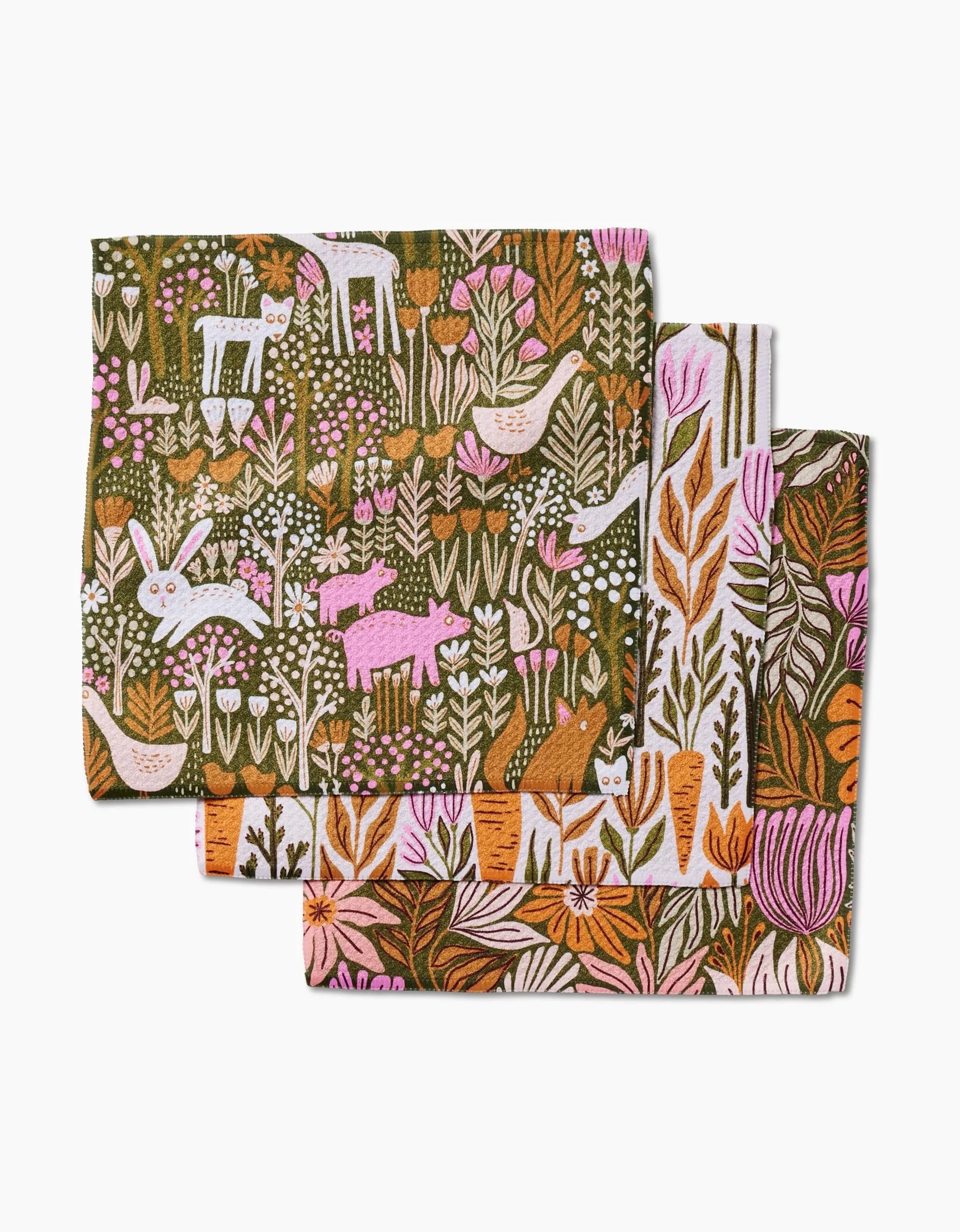 Three folded Callagreen cloth napkins by Amy MacCready, made from recycled materials with a colorful woodland pattern of flowers, leaves, rabbits, cats, and birds covering the entire surface.