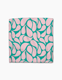 The Cheetah Haven dishcloth set by Jasmine Blooms Designs features folded pink cloths with a teal abstract, teardrop-like pattern, crafted from recycled materials and shown on a white background.