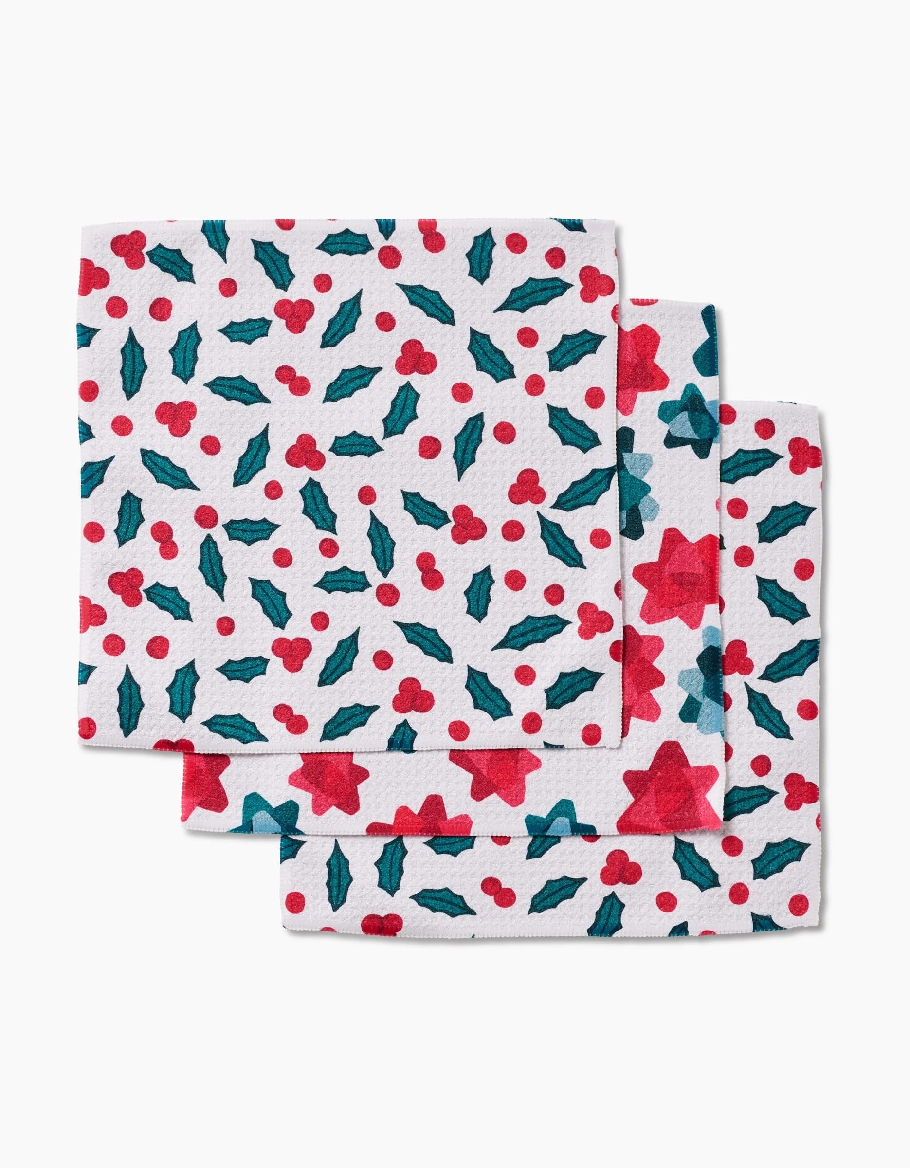 Three Christmas Bows dishcloths by Rebecca Bobko feature a festive red star, berry, and holly pattern. Made from super-absorbent recycled materials, they’re perfect for eco-friendly holiday cleanups. Photographed stacked on a white background.