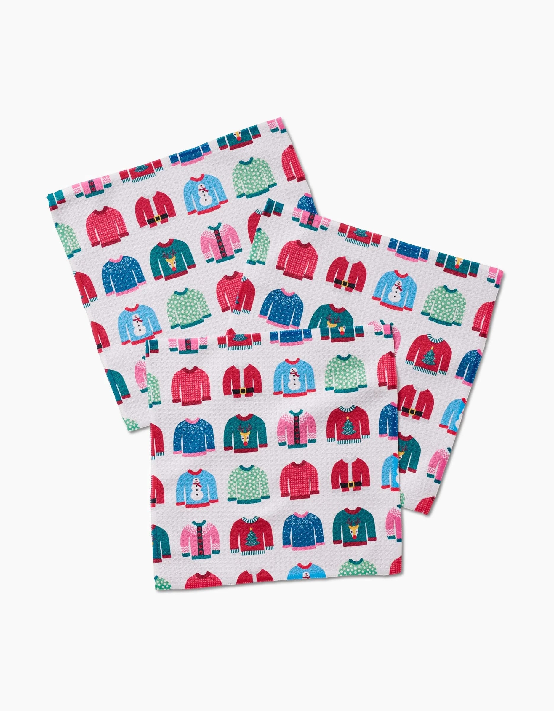 Rebecca Bobko’s Christmas Sweaters Geoweave dishcloths feature festive sweater patterns with snowmen, reindeer, and trees on a white background. Made from recycled materials for eco-friendly cleaning.