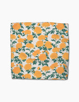 The Chrysanthemum dishcloth by Vaishali Design Studio features a square shape with a vibrant orange floral and green leaf pattern on white, made from durable Geoweave fabric using recycled materials.