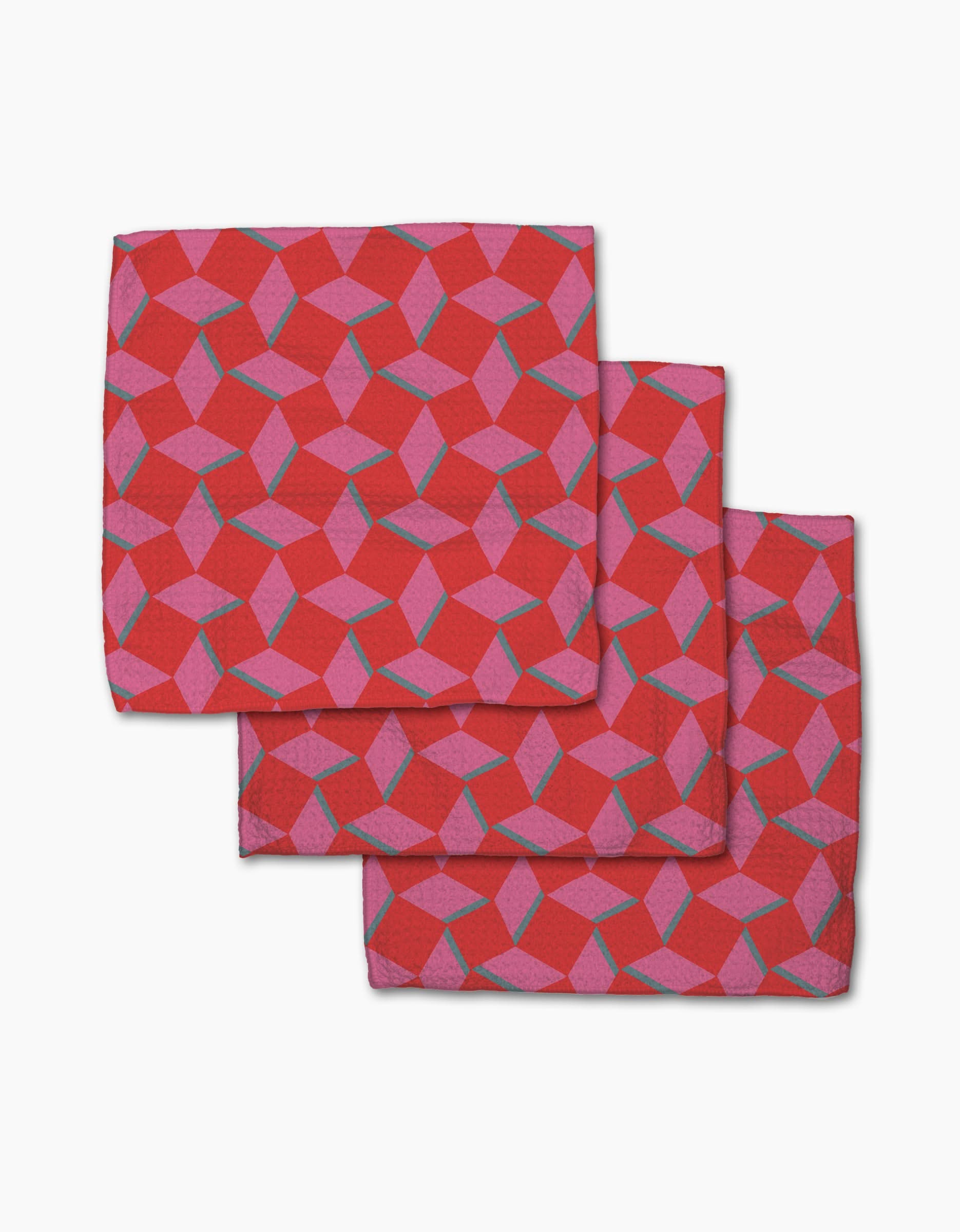 Three Circus Stand napkins by Geometry, featuring a pink and purple geometric cube pattern on Geoweave fabric, are stacked with slight overlap on a white background.