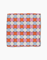 The Claire Iglesias Color Block Grid Dishcloth Set features a super-absorbent design with orange, pink, and blue squares outlined by white and small dark blue squares at the intersections on a white background.