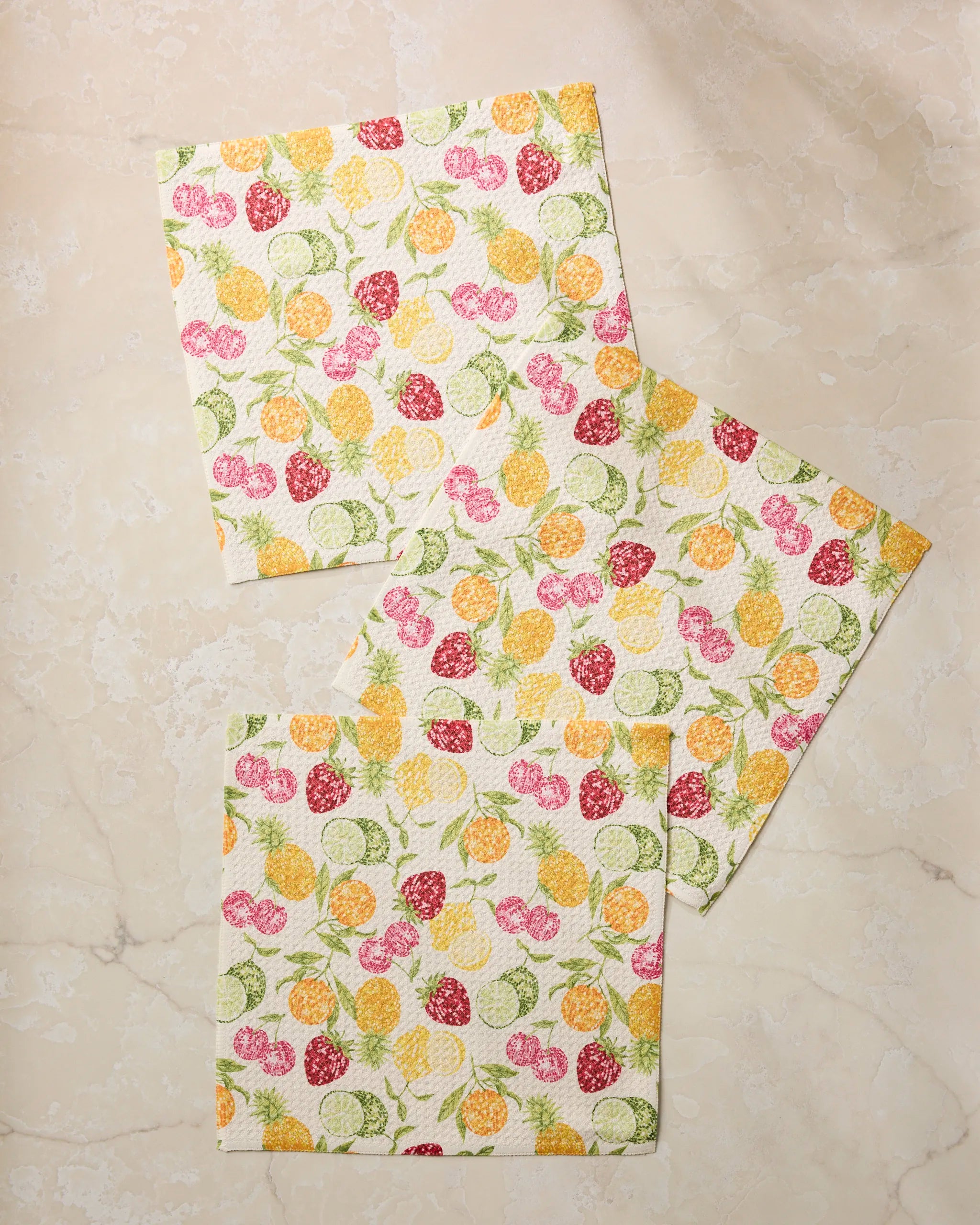 Three Geometry Disco Fruits paper napkins, featuring vibrant lemons, limes, pineapples, and raspberries on a marble background, add a cheerful touch to your table or pair perfectly with absorbent kitchen towels.