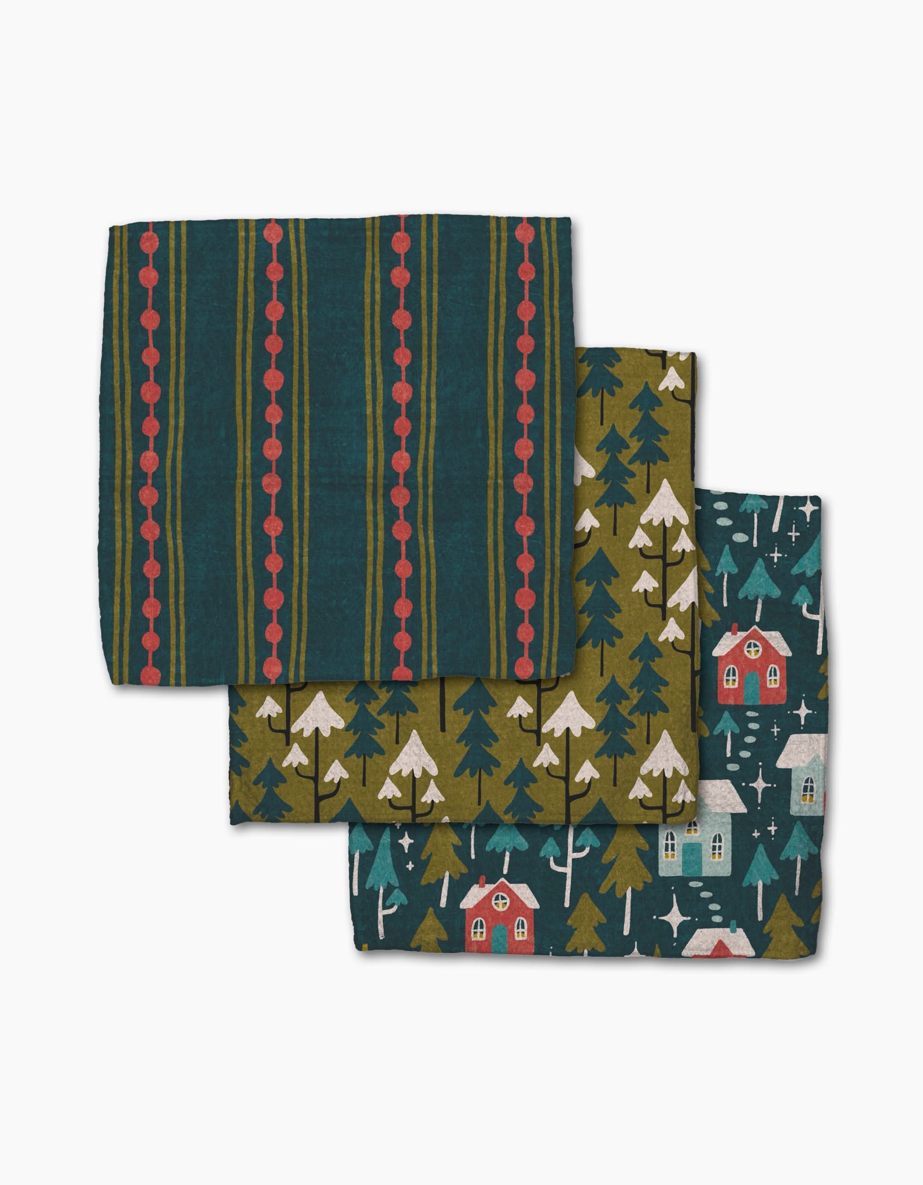Set of three Evervale super-absorbent cloth napkins by Amy MacCready: one with green and red stripes, one with forest trees and cabins on olive, and one with cabins, trees, and snowflakes on dark teal.