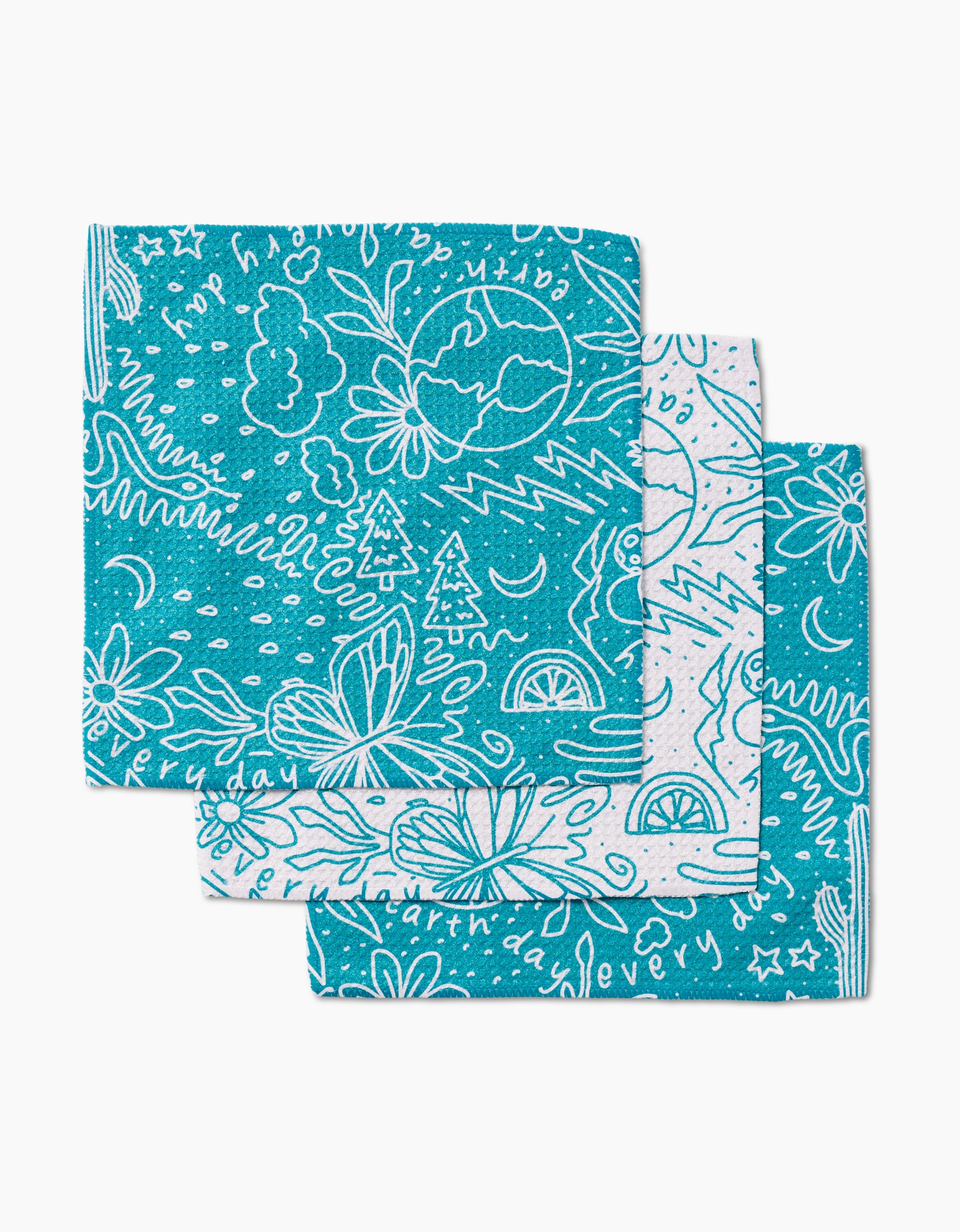 The GEOMETRY Every Day set includes three teal dishcloths made from recycled materials, each featuring whimsical white line drawings of clouds, trees, butterflies, suns, and abstract shapes.