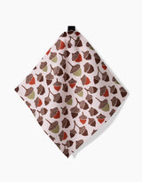 The Kayla Ann Fall Abundance dishcloth, crafted from Geoweave fabric, showcases brown, red, and green acorns and leaves on a light background and hangs from a black loop against a white surface.