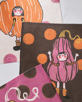 Geometry’s Fall Day Parade features three vibrant, eco-friendly fabric pieces with playful pumpkin-costumed girls and cheerful polka dots in warm fall shades.