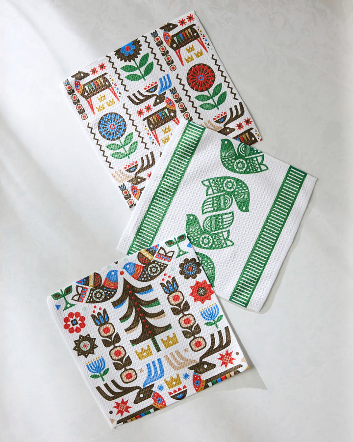The Festive Folk dishcloth set by Geometry features super-absorbent towels with colorful, folk-inspired patterns made from recycled materials—adding a unique touch to your kitchen decor.