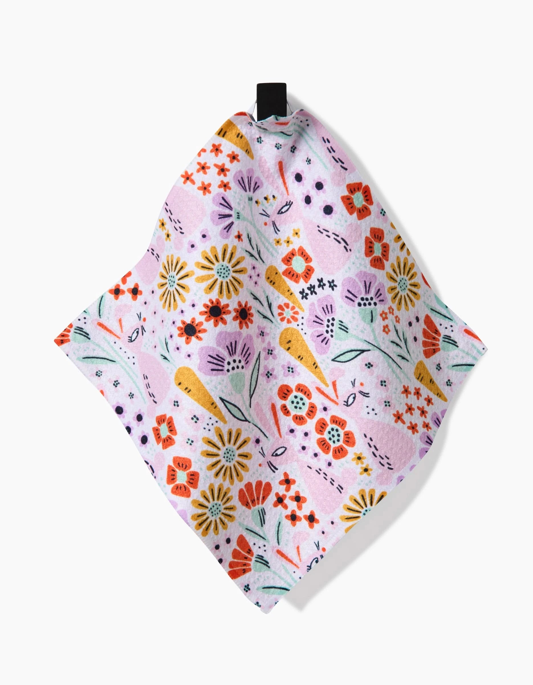 The Floppsie Lilith and Thaddeus napkin by Amy MacCready is a square, pastel pink cloth made from recycled materials, featuring a colorful floral design and hanging from a black loop against a white background.