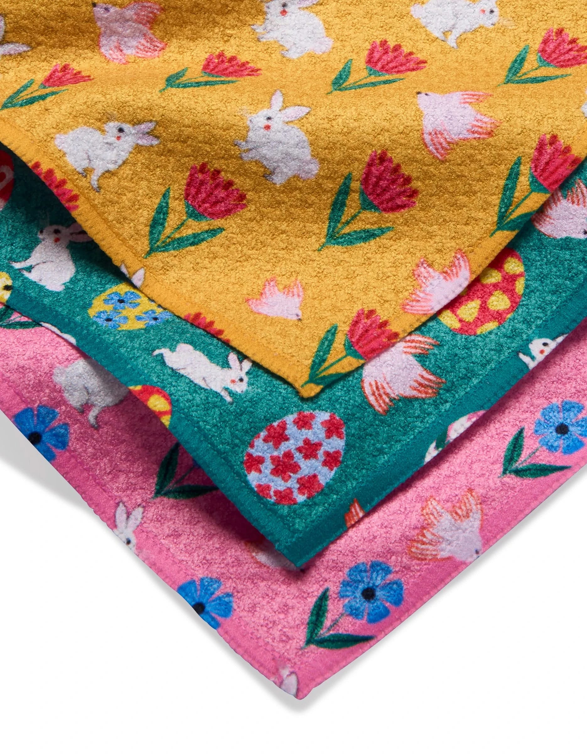 The Floral Easter Parade dishtowel set by Ceyda Alasar features three colorful, super-absorbent towels with bunny, egg, and flower patterns on yellow, teal, and pink backgrounds—perfect for festive Easter kitchen decor.