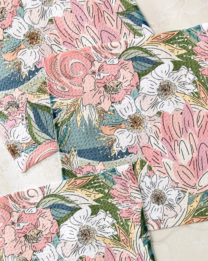 The Second Nature Studio Flower Explosion dishcloth set includes three super-absorbent towels with pink, white, and green floral patterns, made from recycled materials for an eco-friendly and artistic kitchen touch.