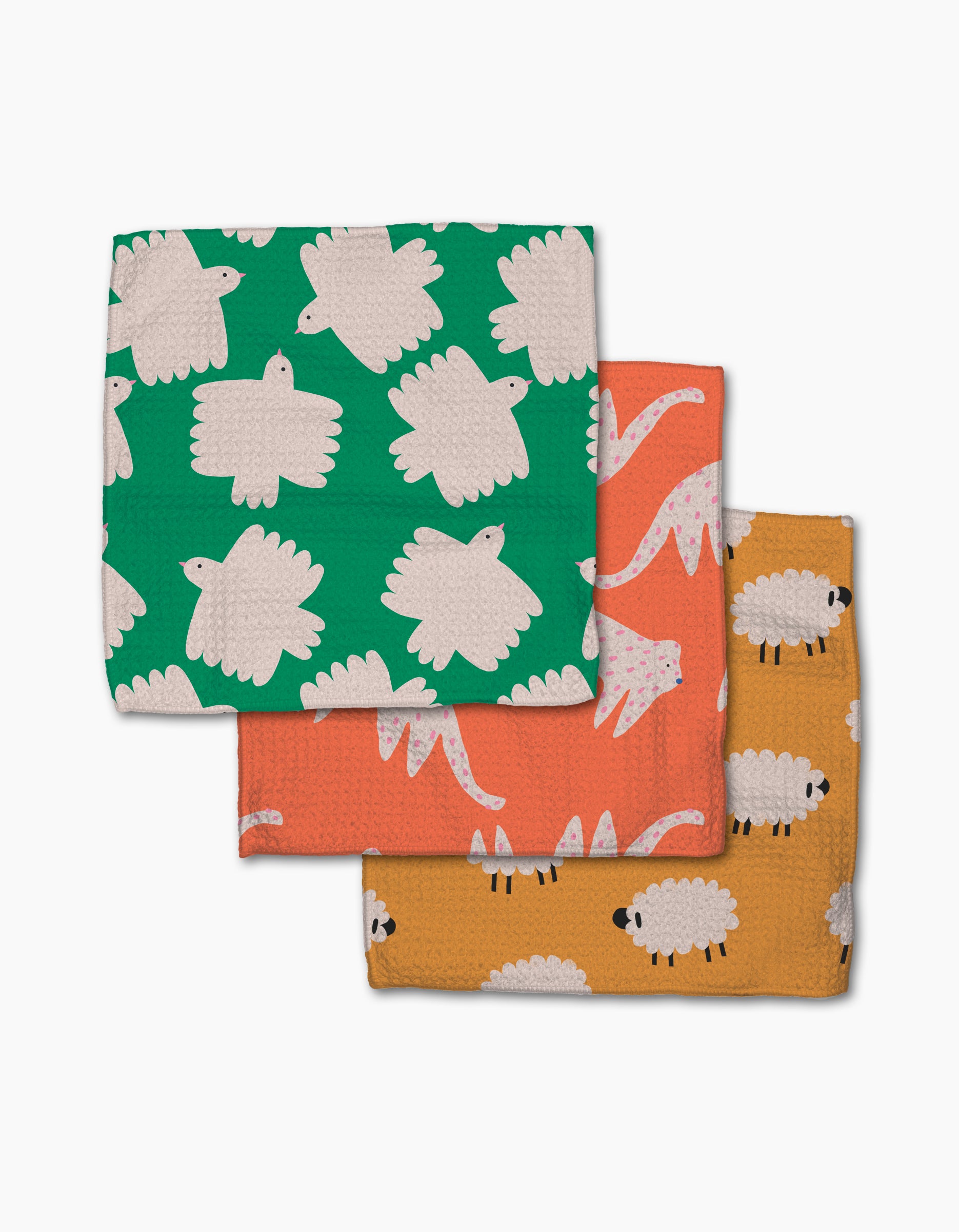 Fluff and Feathers by Jennifer Bouron: three recycled Geoweave dishcloths featuring playful animal prints—white sheep on green, pink dinosaurs on orange, and white sheep on mustard yellow—with a textured surface.