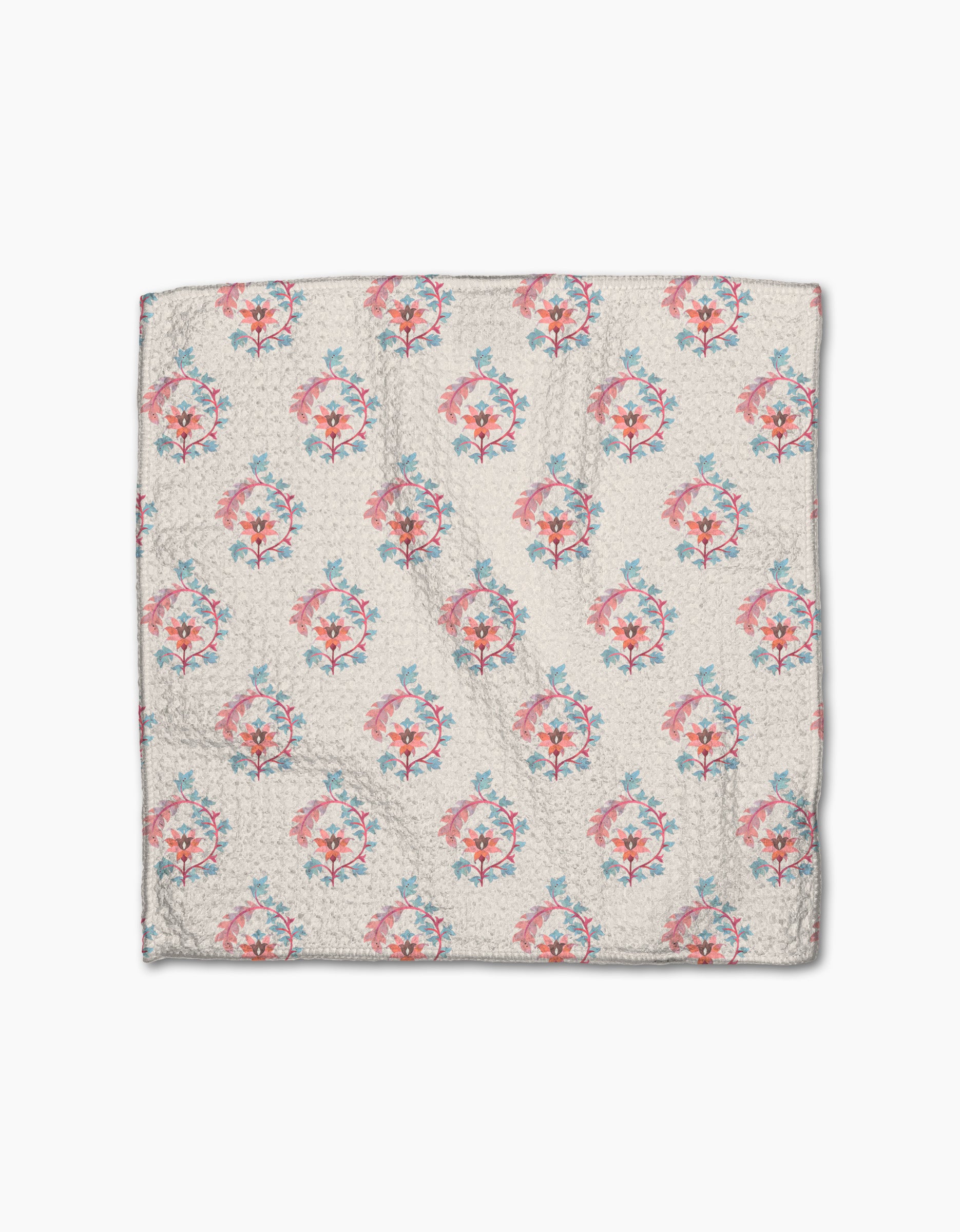 The Folk Medallion quilt by Maayan Alper-Swan is a square, light-toned piece made from recycled materials, showcasing a textured surface with evenly spaced pink and blue floral patterns.