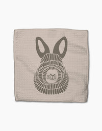 Forest Animals by Rosa Kichline: A beige textured cloth made from recycled materials, featuring a stylized gray bunny face with large ears and geometric fur, set against a white background.